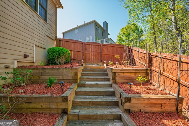 wooden deck with a fenced backyard and a gate