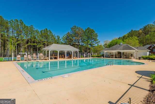 community pool featuring a gazebo, fence, and a patio