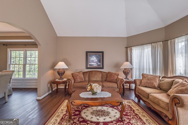 living room with baseboards, arched walkways, dark wood-style floors, and high vaulted ceiling