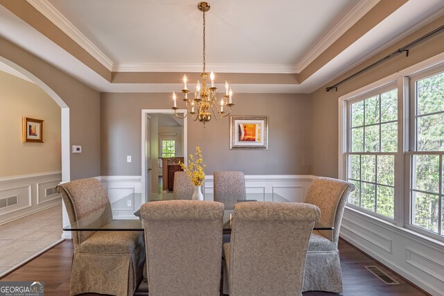 dining space featuring visible vents, a decorative wall, a notable chandelier, and a healthy amount of sunlight