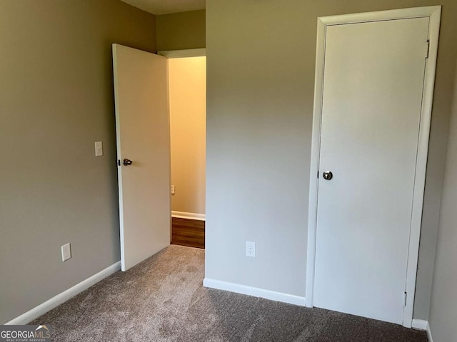 unfurnished bedroom with carpet flooring and baseboards