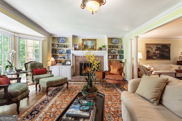 812 Burning Tree Ct SE, Marietta, GA 30067 - living area featuring ornamental molding, a brick fireplace, wood finished floors, built in features, and ornate columns