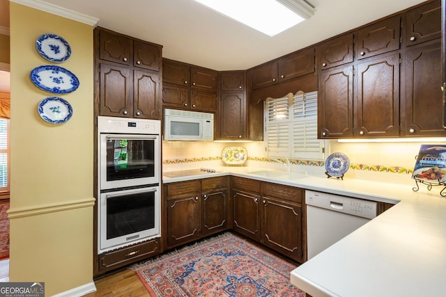 812 Burning Tree Ct SE, Marietta, GA 30067 - kitchen with white appliances, a sink, light countertops, dark brown cabinets, and wood finished floors