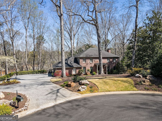 812 Burning Tree Ct SE, Marietta, GA 30067 - view of front of home with decorative driveway, a chimney, brick siding, and a front yard
