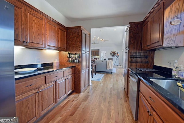 47 Hidden Fields Rd, Hiawassee, GA 30546 - kitchen with dark stone counters, brown cabinetry, light wood-style floors, appliances with stainless steel finishes, and a notable chandelier