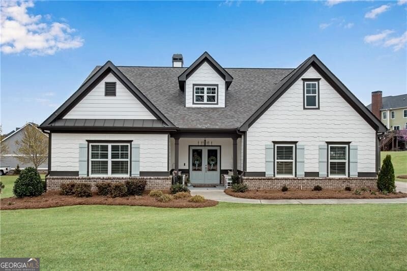 50 Harmony Grove Ln, Jefferson, GA 30549 - view of front facade with french doors, brick siding, a front yard, and roof with shingles