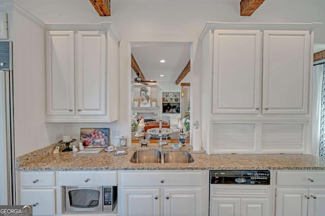 kitchen with stainless steel microwave, white cabinetry, dishwasher, and light stone counters
