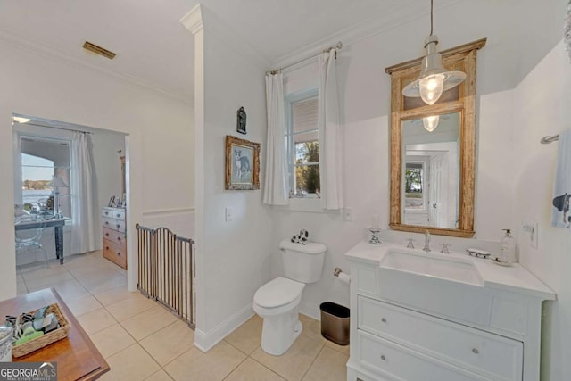 bathroom with toilet, vanity, crown molding, and tile patterned floors