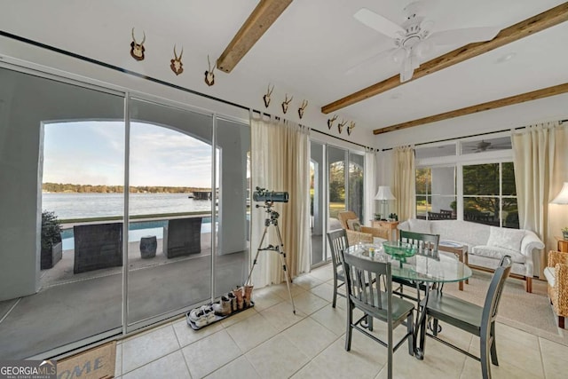 sunroom featuring tile patterned flooring, a water view, and beamed ceiling