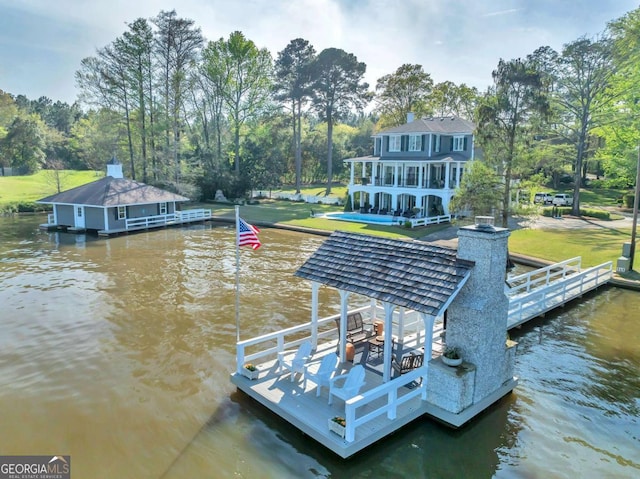 view of dock with a water view and a lawn