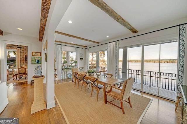 dining area featuring a water view, baseboards, recessed lighting, beam ceiling, and light wood-type flooring