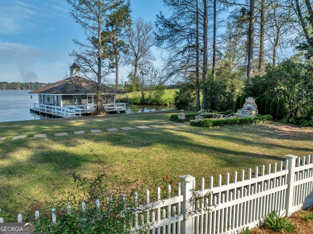 view of yard featuring a water view and fence