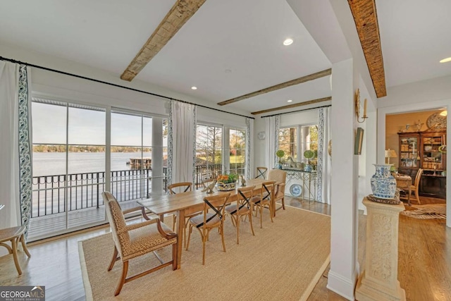dining area featuring a water view, recessed lighting, beam ceiling, and light wood-type flooring