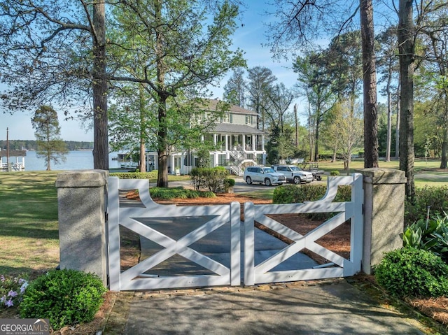 view of gate featuring a water view and a yard