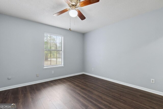 empty room featuring dark wood-style floors, ceiling fan, baseboards, and a textured ceiling