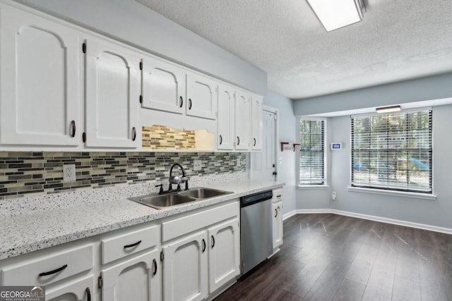 kitchen with a sink, white cabinetry, stainless steel dishwasher, dark wood finished floors, and decorative backsplash