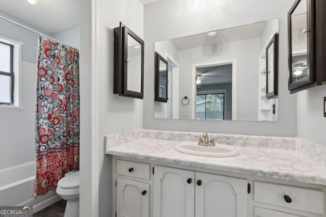 full bath featuring a textured ceiling, toilet, shower / tub combo, and vanity