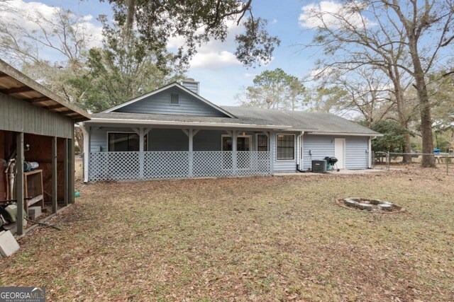 view of front of home featuring a chimney, central AC unit, and a porch