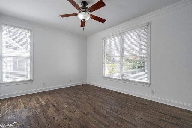 spare room with ornamental molding, baseboards, and dark wood finished floors