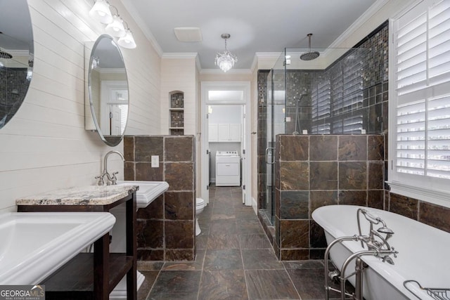 full bathroom with washer / clothes dryer, ornamental molding, a sink, a stall shower, and a freestanding bath