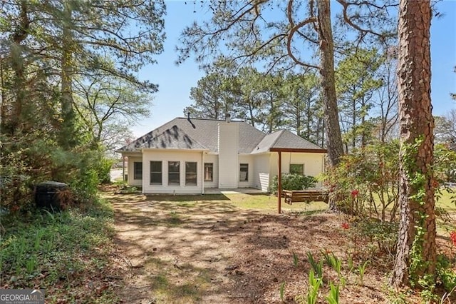 back of house with a shingled roof