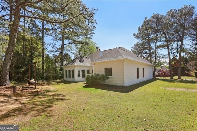 back of property with a lawn and a chimney