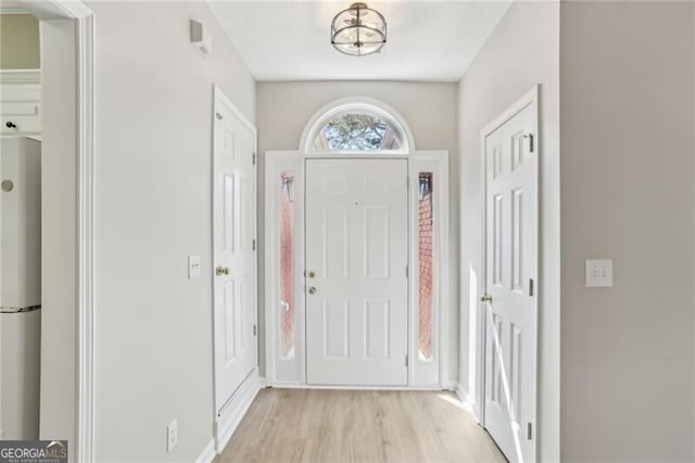 foyer with baseboards and light wood finished floors