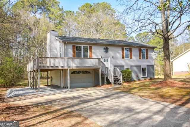 759 Oak Grove Rd, Carrollton, GA 30117 - bi-level home featuring an attached garage, concrete driveway, stairway, a wooden deck, and a chimney