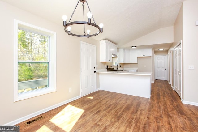 759 Oak Grove Rd, Carrollton, GA 30117 - kitchen with a peninsula, a notable chandelier, white cabinets, visible vents, and light countertops