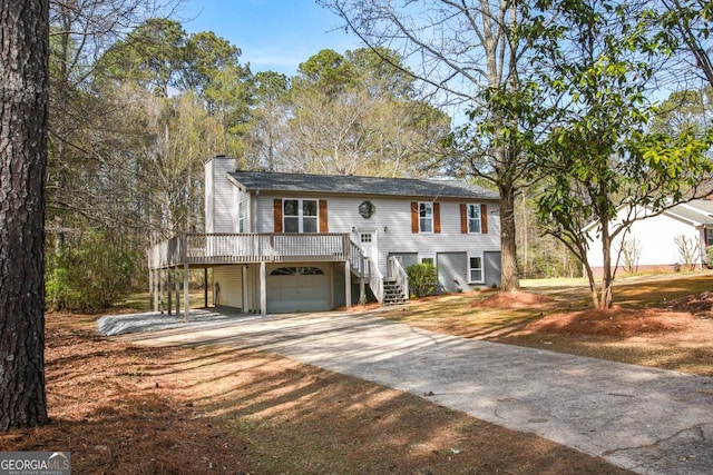 759 Oak Grove Rd, Carrollton, GA 30117 - raised ranch featuring an attached garage, driveway, stairway, a wooden deck, and a chimney