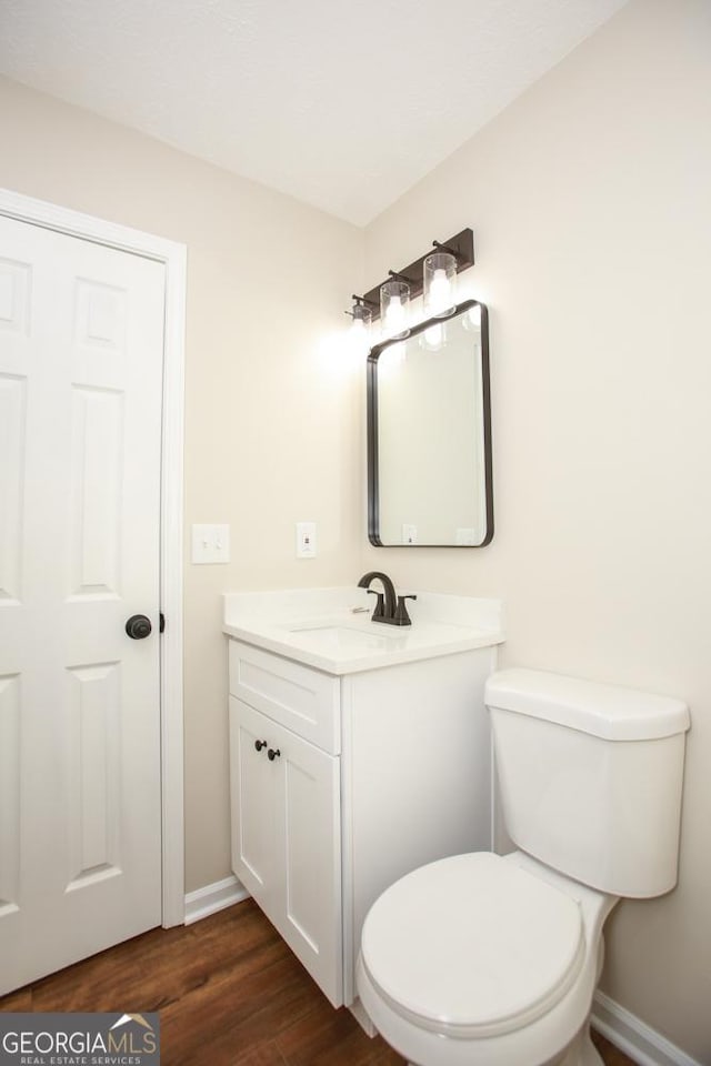 759 Oak Grove Rd, Carrollton, GA 30117 - bathroom with toilet, baseboards, wood finished floors, and vanity