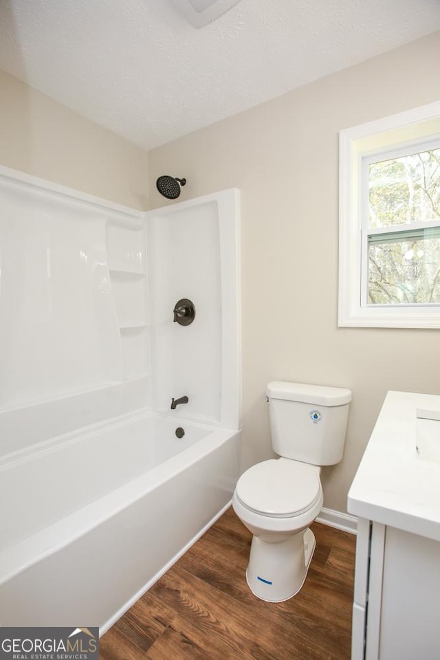 759 Oak Grove Rd, Carrollton, GA 30117 - full bath with toilet, wood finished floors, vanity, tub / shower combination, and baseboards