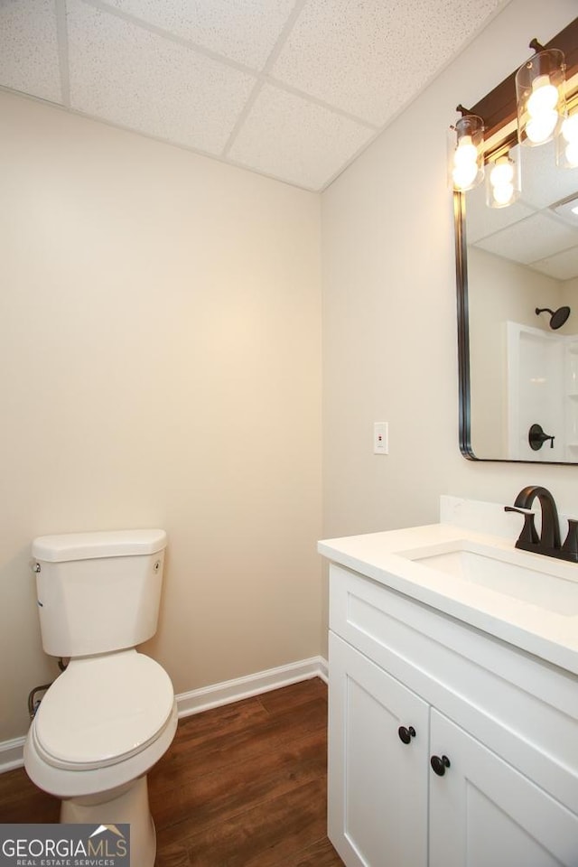 759 Oak Grove Rd, Carrollton, GA 30117 - bathroom featuring wood finished floors, a drop ceiling, baseboards, and toilet