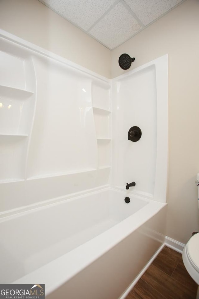 759 Oak Grove Rd, Carrollton, GA 30117 - full bathroom with toilet, wood finished floors, shower / tub combination, a paneled ceiling, and baseboards