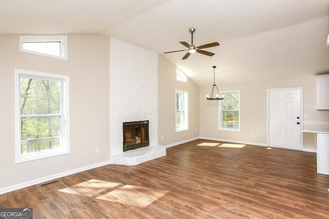 759 Oak Grove Rd, Carrollton, GA 30117 - unfurnished living room with visible vents, wood finished floors, ceiling fan with notable chandelier, and a stone fireplace