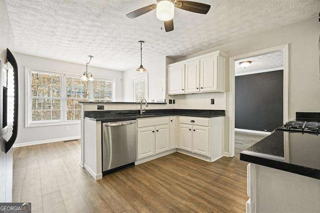 802 Eagle Glen Xing, Woodstock, GA 30189 - kitchen with stainless steel dishwasher, dark wood-style flooring, dark countertops, and a textured ceiling
