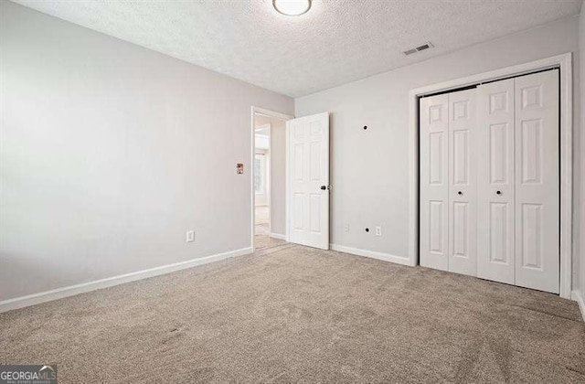 802 Eagle Glen Xing, Woodstock, GA 30189 - unfurnished bedroom featuring carpet flooring, a textured ceiling, and a closet