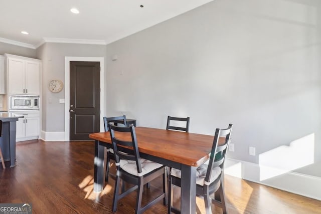 dining area with ornamental molding, dark wood finished floors, baseboards, and recessed lighting