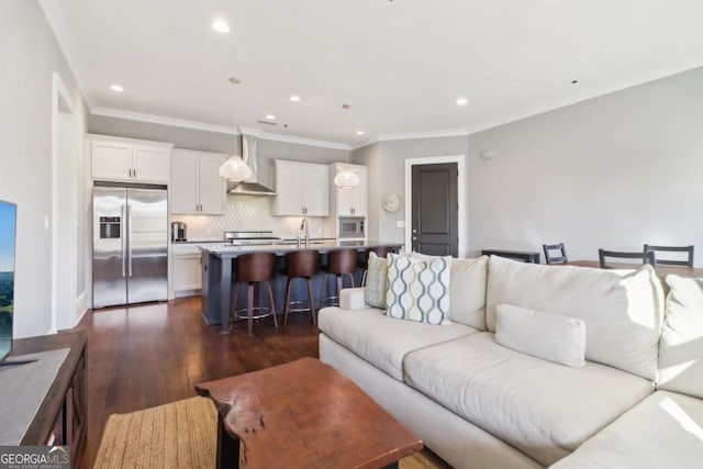 living area featuring dark wood-style flooring, recessed lighting, and crown molding
