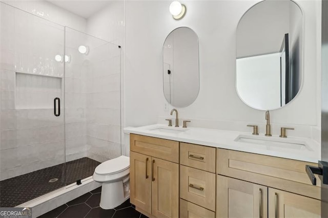 full bath featuring double vanity, a sink, toilet, and a shower stall
