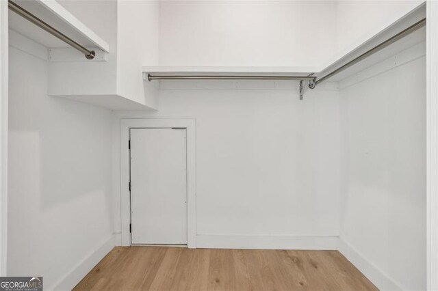 walk in closet with light wood-type flooring