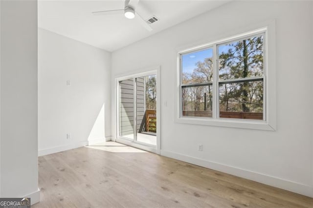 unfurnished room with baseboards, visible vents, wood finished floors, and a ceiling fan