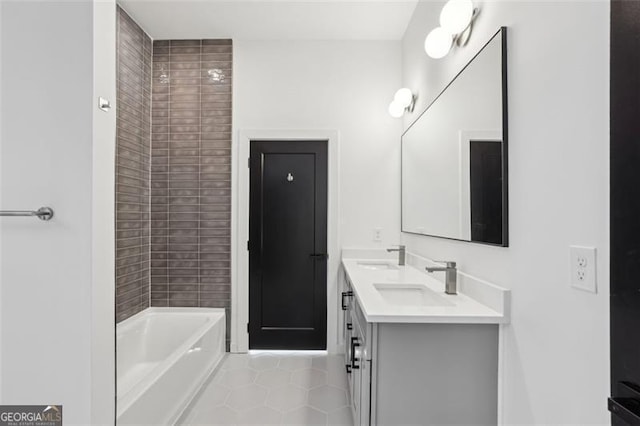bathroom with double vanity, tile patterned flooring, a sink, and a bathtub
