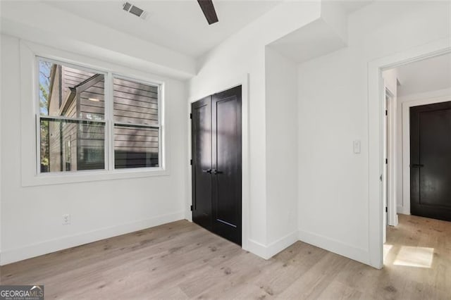 interior space featuring baseboards, light wood-style flooring, and visible vents
