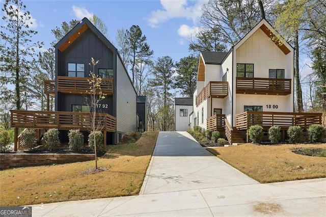 view of front facade featuring a balcony, board and batten siding, and concrete driveway