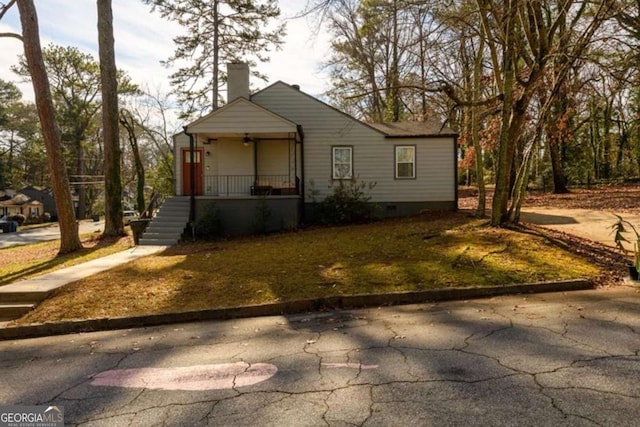view of front of home featuring crawl space, a chimney, and a porch