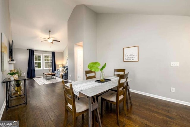 dining area featuring baseboards, high vaulted ceiling, ceiling fan, and dark wood-type flooring
