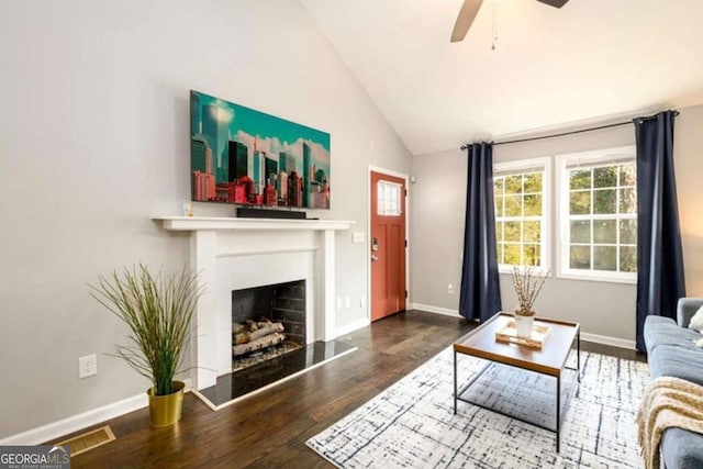living area featuring visible vents, baseboards, wood finished floors, a ceiling fan, and vaulted ceiling