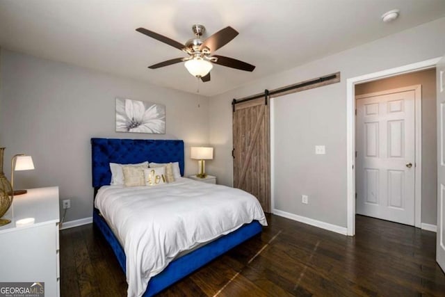 bedroom with baseboards, a barn door, ceiling fan, and wood finished floors