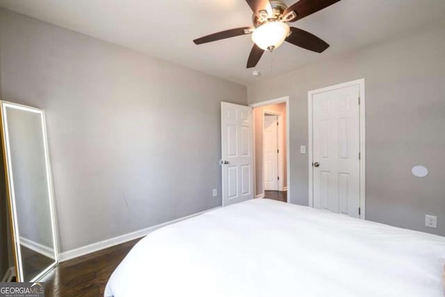 bedroom featuring a ceiling fan, dark wood-style flooring, and baseboards